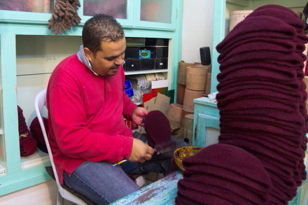 Kepurių dirbėjas šukuoja tradicinę tunisietišką kepuraitę 